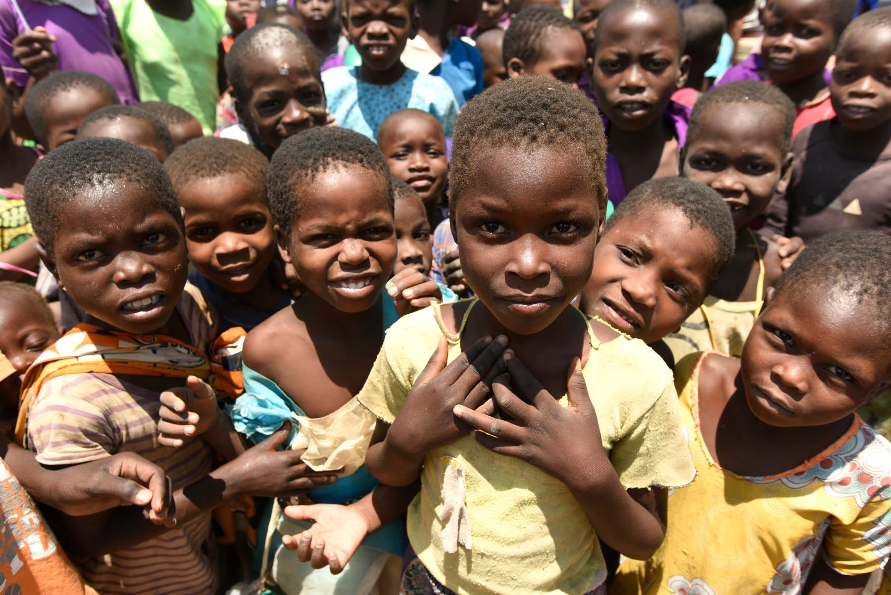 A group of smiling children in a community served by NNN member organisations.